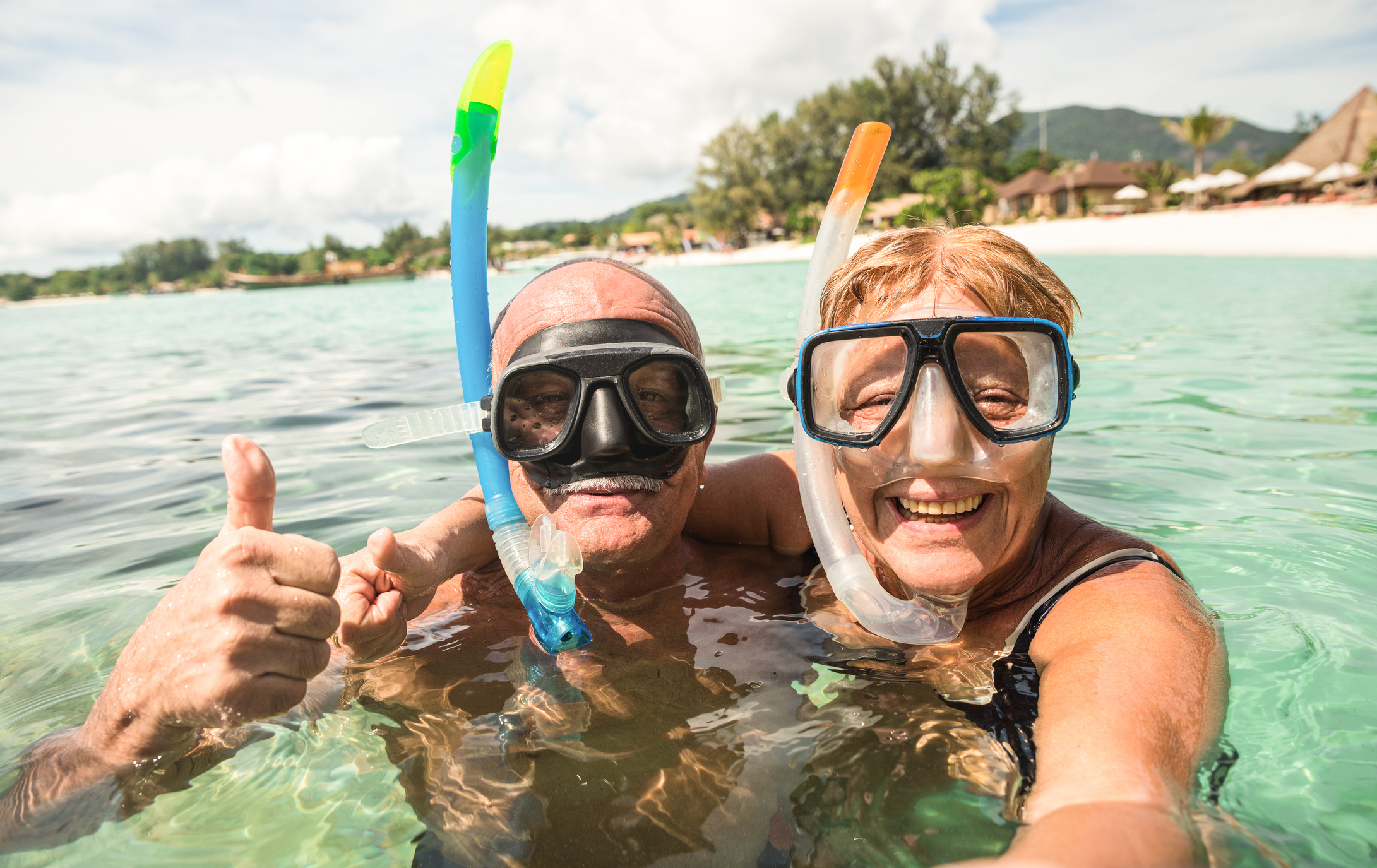 Senior happy couple taking selfie in tropical sea excursion with water camera - Boat trip snorkeling in exotic scenarios - Active retired elderly and fun concept around the world - Warm bright filter Beatrice Bradley Couples